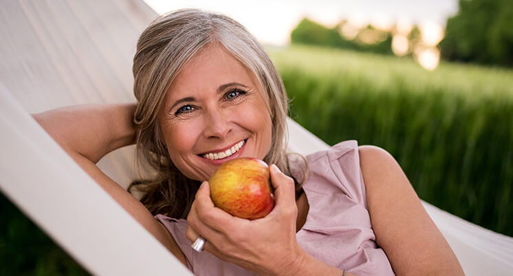 woman with implants eating apple