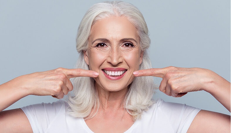 woman pointing at her smile