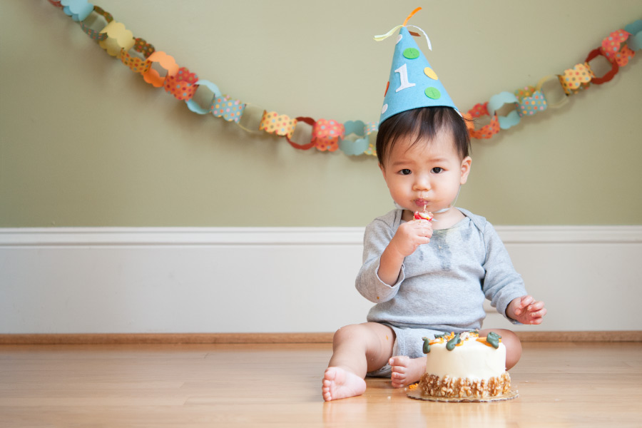 A baby eats cake for his first birthday before his first visit to the dentist