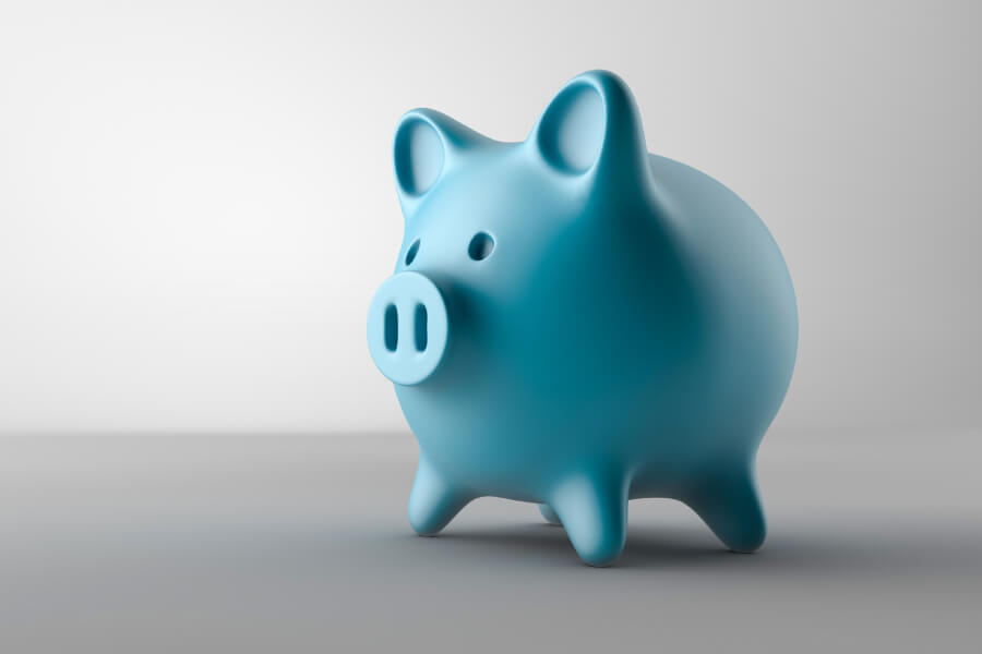 Blue piggy bank on a gray background for a post about saving money with a dental membership plan